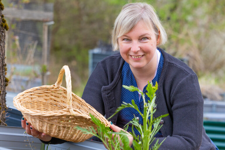 Anita Arneitz mit Kräuterkorb und Hochbeet
